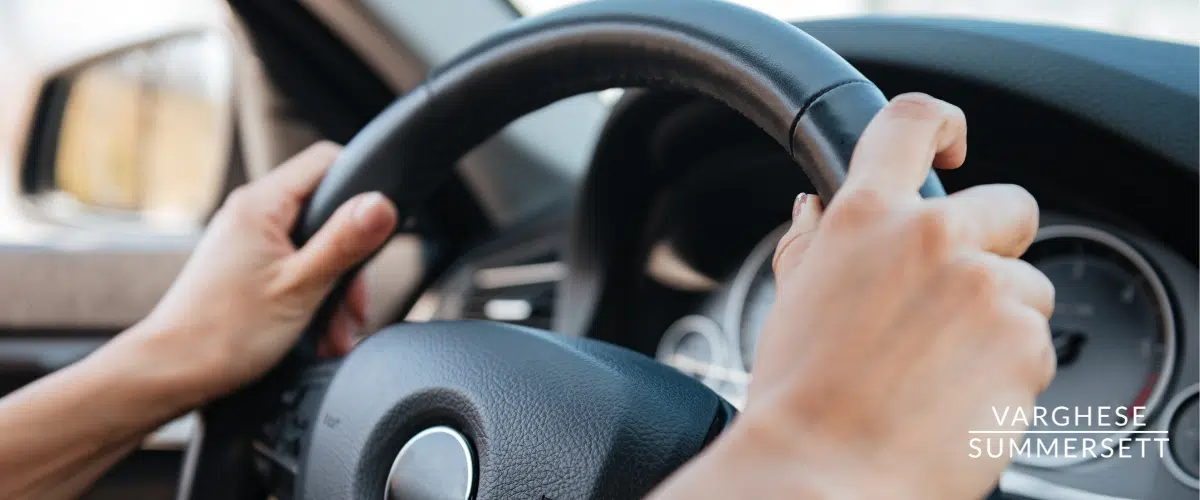 Hands on car steering wheel