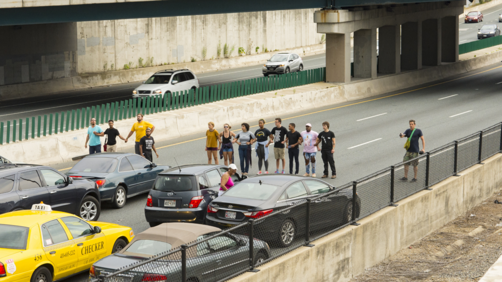 people protesting and stopping traffic on freeway 